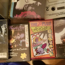 Audio Garbage cassette next to Prince's Purple Rain and other tapes from the 80's