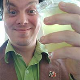 Lemon holding a margarita and wearing an F Plus pin