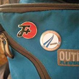 An F Plus pin on a Outdoor backpack next to a Official Team Space IL pin