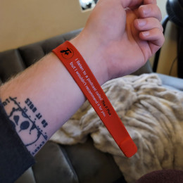 a slap bracelet around paradigm's wrist