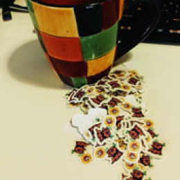 a whole bunch of tiny stump stickers next to a coffee cup